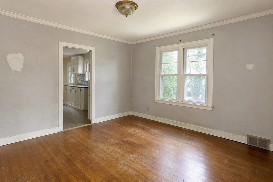 Before fix up renovation showing scuffed walls worn flooring old trim dated paint and lighting for Cerpa Construction LLC.