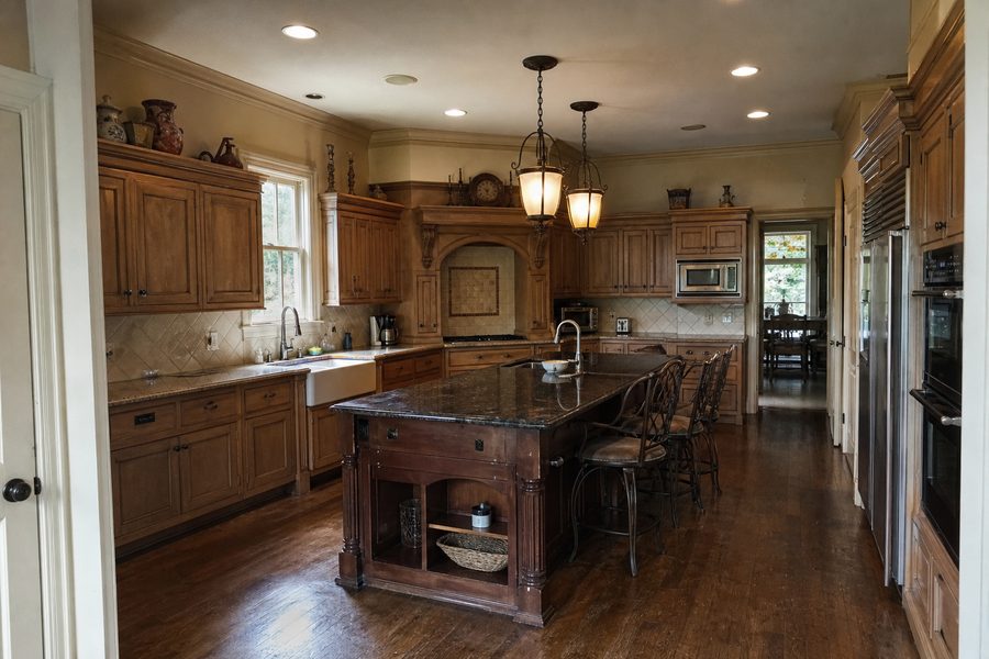 Before high end kitchen renovation showing dated cabinets older island counters appliances lighting and floors for Cerpa Construction LLC.