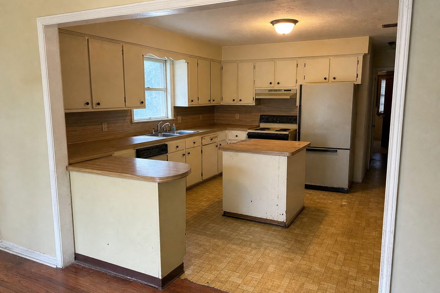 Before kitchen renovation by Cerpa Construction LLC showing outdated cabinets counters flooring lighting and appliances in Memphis TN.